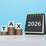 2026 desk calendar, Wooden blocks with the word TAX and stack of coins