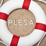 Life ring in sand with letters "PLESA" in the middle