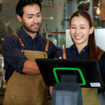 Man and women at a coffee shop standing in front of the checkout key pad
