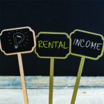 Three small signs- 1. with an image of a lightbulb 2. with the word "rental" 3. with the word "income"