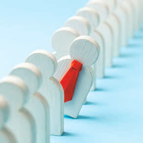 Wooden images of people lined up and one tilted out of line with a red tie