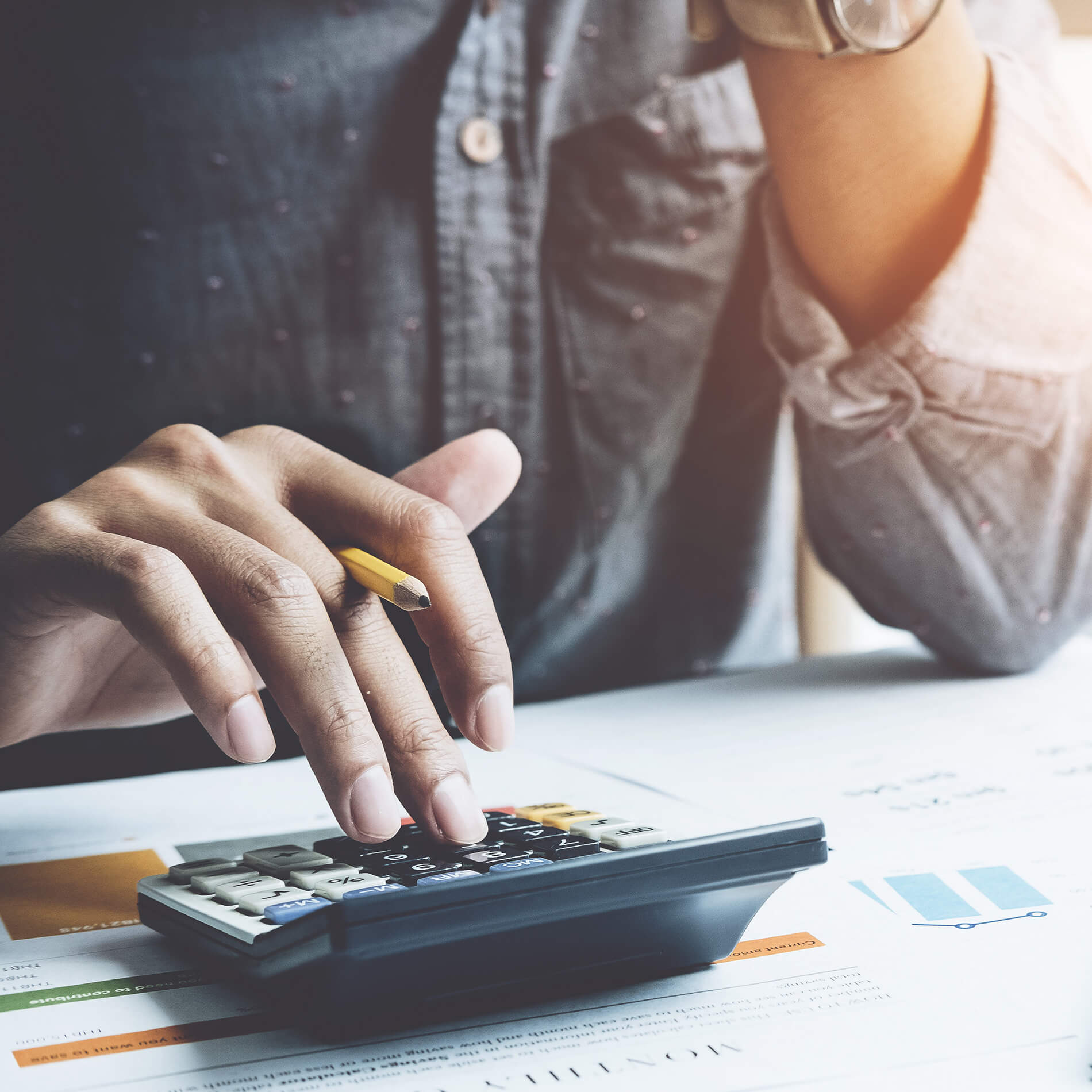 Hand typing on a calculator
