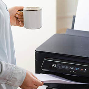 Office job. Secretary or office manager woman using printer, scanner or laser copy machine.