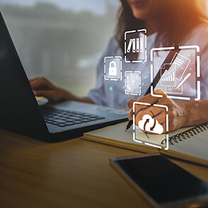 Person typing at a laptop with computer graphics laid over image