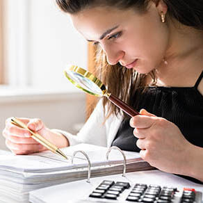 Fraud Investigation And Tax Audit. Investigator Or Auditor Using Magnifying Glass