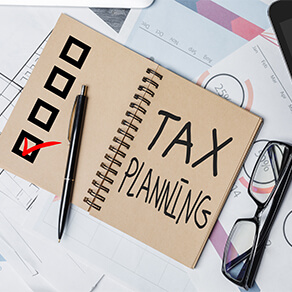 op view of office desktop with paperwork, glasses and other items. Tax planning concept