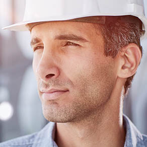 Close up of man in light shirt protective construction helmet