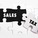 Words "SALES TAX" on white and black puzzle
