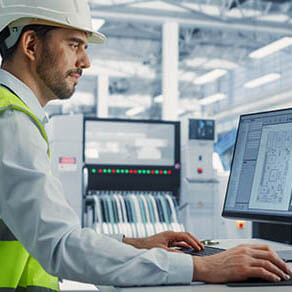 Male electrical engineer works on desktop computer