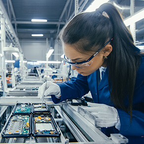Shot of an Electronics Factory Workers Assembling Circuit Boards by Hand While it Stands on the Assembly Line. High Tech Factory Facility.