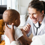 Happy Doctor examining baby