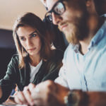 A couple sitting close looking intently at a computer screen