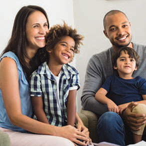 Family of four sitting together and smiling