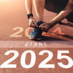 Runner tying his shoe at the start line of a race with "2024" on one side of the start line and "2025" on the other