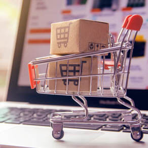 Miniature shopping cart on laptop keyboard