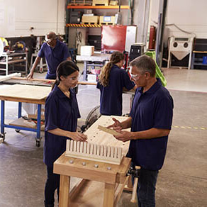 A man and a woman discussing something over a table in a warehouse