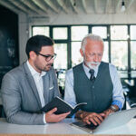 Handsome young and mature business men discussing work.