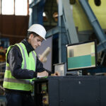 Man in construction facility working on a computer