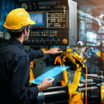 Male employee showing automation manufacturing process with smart industry robot arms for digital factory production technology