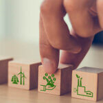 Wooden cubes with CO2, US dollars and carbon offsetting solution icons.