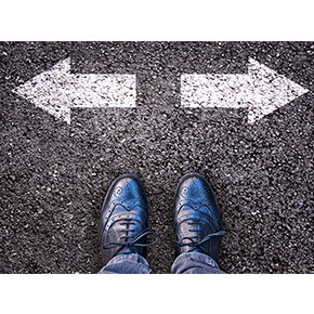 Man shoes with two arrows point in opposite directions on pavement