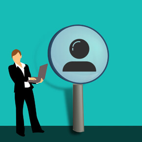 Person holding laptop and image of person inside a magnifying glass