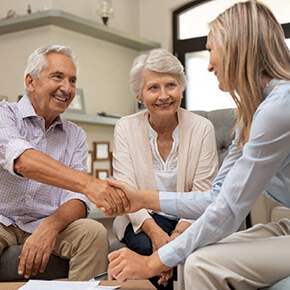 Woman shaking hands with older couple after signing a paper
