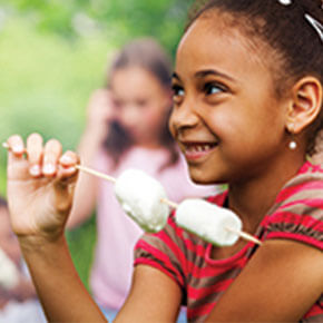 Little girl with marshmallows on a stick