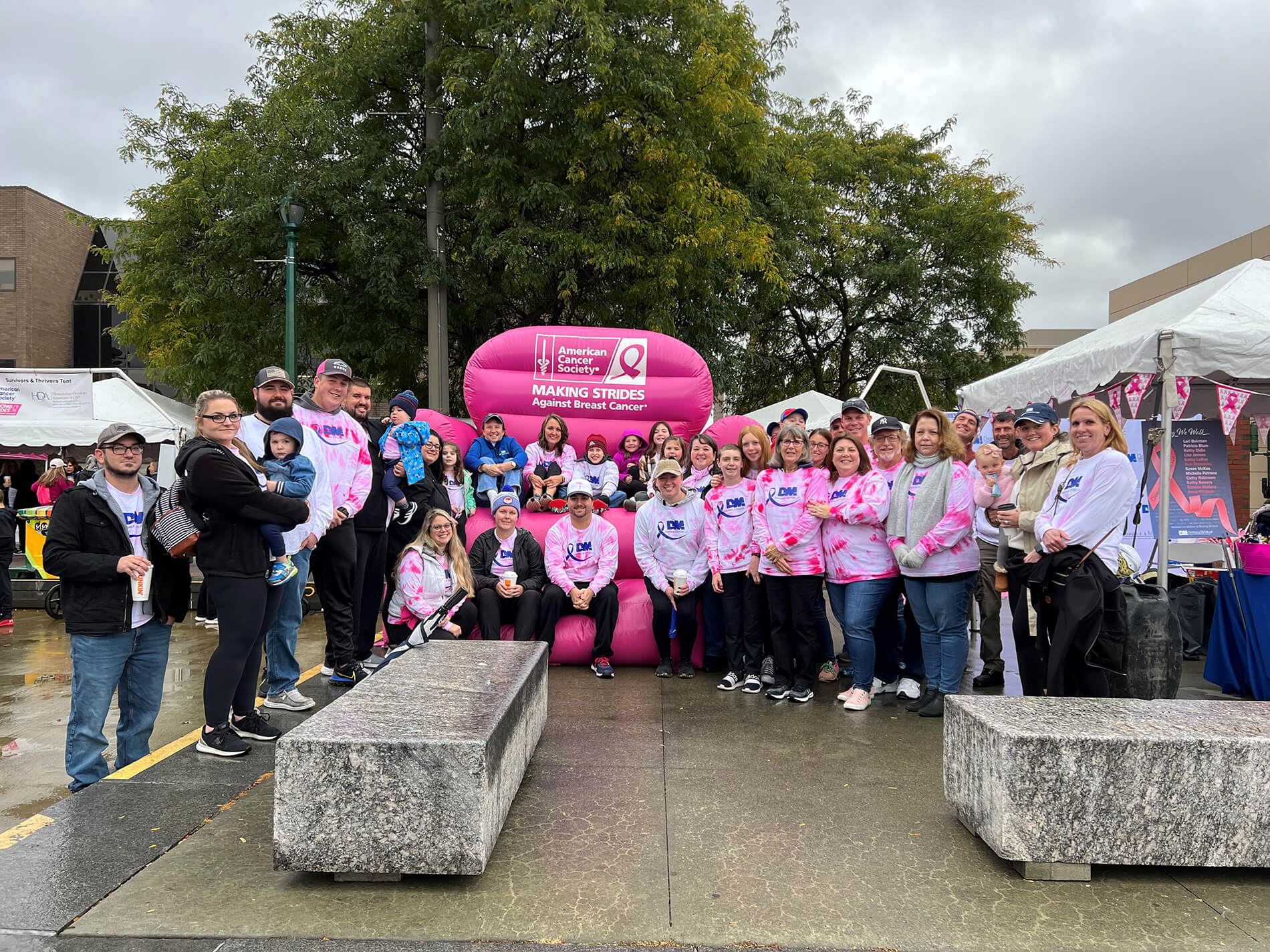 Employees at Making Strides Walk in front of the big pink chair.
