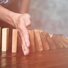 Hand catching a line of wooden blocks from tumbling