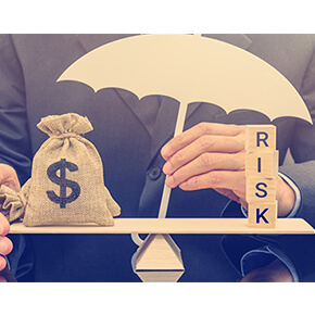 Man sitting with a scale with blocks on one side spelling RISK and a money bag with dollar symbol on it and his hand holding an umbrella