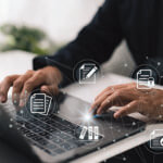 Hands typing on a laptop with graphics over laid