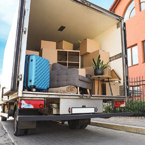 Back of a moving truck full of suitcases and boxes