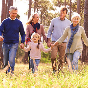 Family with grandparents running in the grass