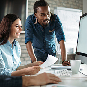 Workers gathered around a computer viewing information