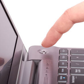 Person pressing power button on laptop