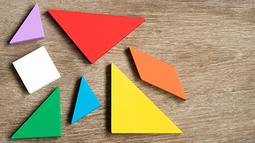 Straggled tangram puzzle wait to complete the shape on wood background