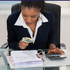 Woman looking at paper with magnifying glass